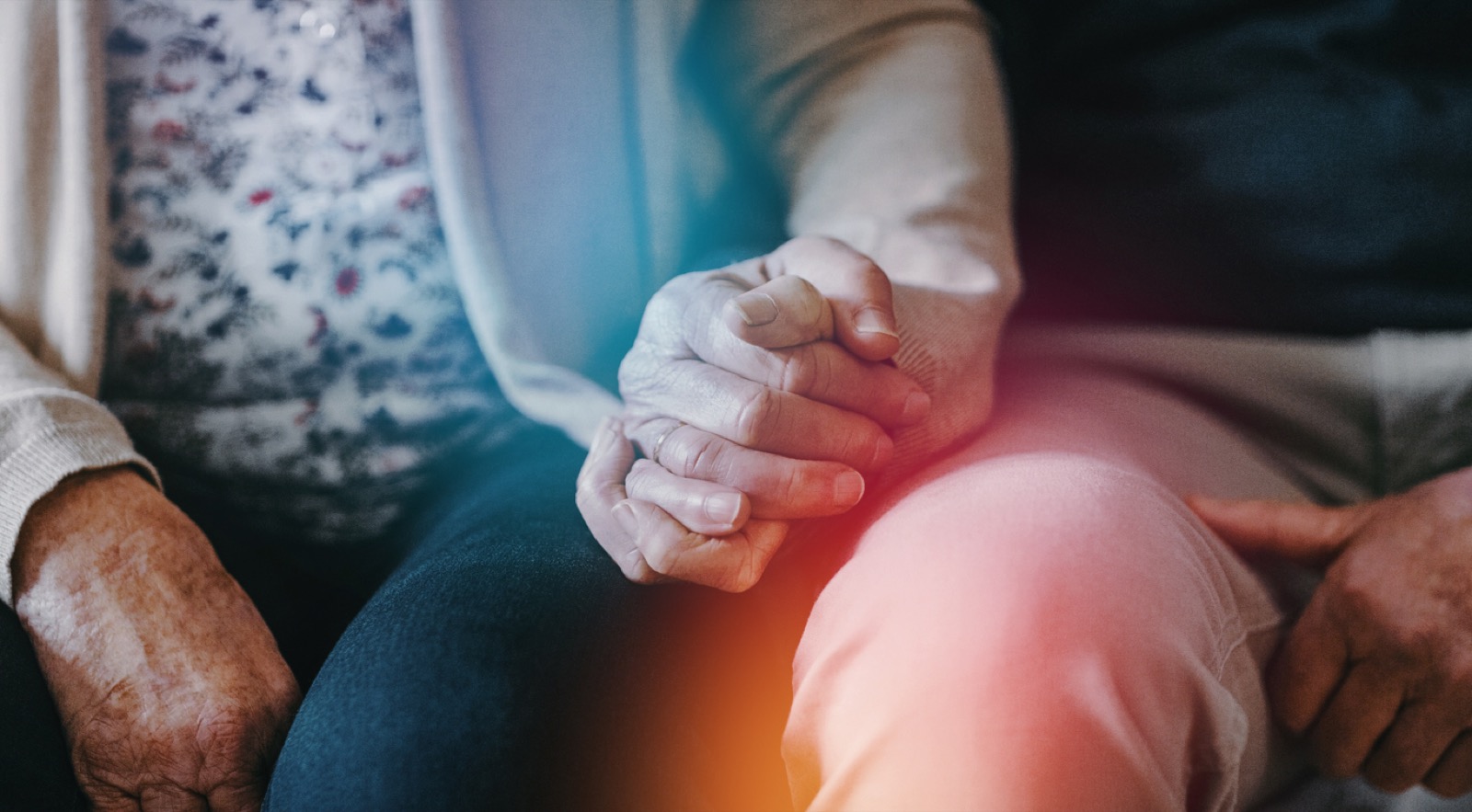 Intimate moment — hands clasped together with prismatic light